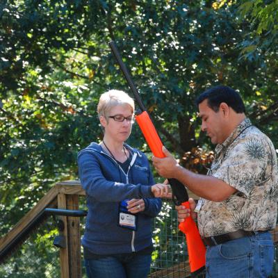 An instructor teaching safe firearms handling to a workshop participant.